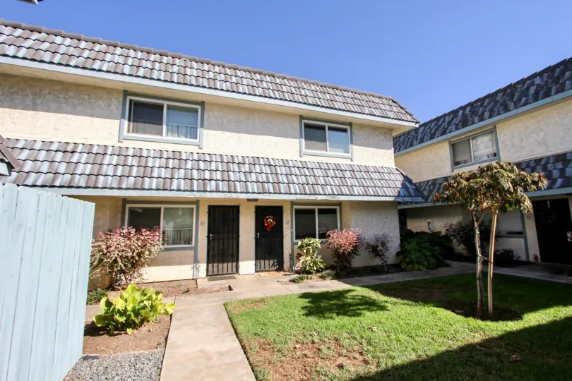 Mosaic tiled roof with simple landscaping features and textured stucco exterior at Centre Villas