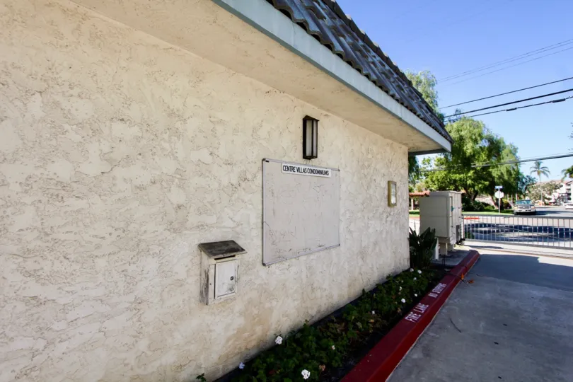 THE VILLAS IN THE CENTRE VILLAS WITH THE CENTRE VILLAS CONDOMINUS BOARD, TREES, CAR