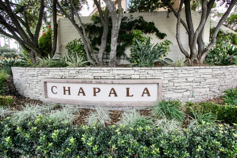 Signage with lush landscaping at the entryway to Chapala in Chula Vista, California