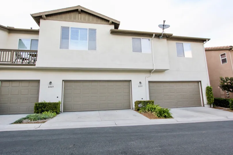 A large, three-garage home in the Cottage Lane neighborhood of Chula Vista, CA, with well-trimmed plants