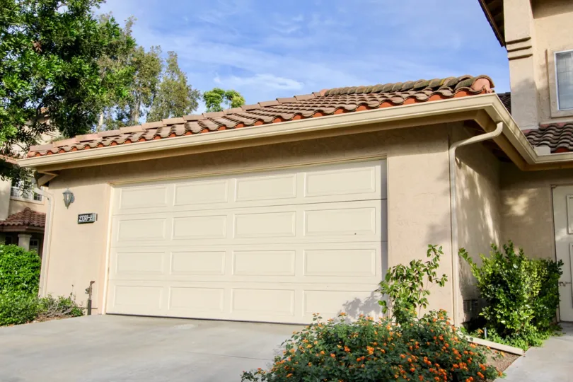 A white garage door on a pink garage inside Fairway Villas in Chula Vista CA