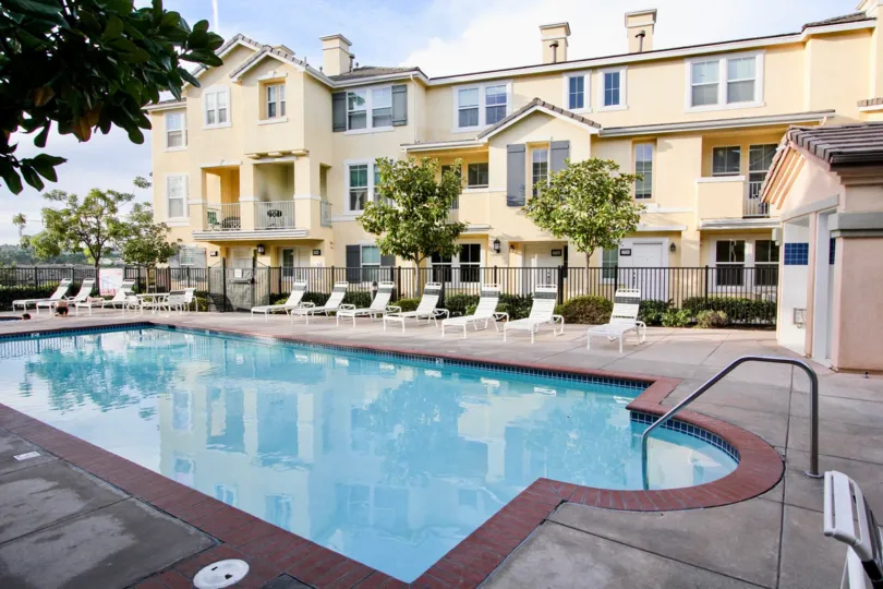 A still pool reflects a pale yellow building at Graystone condos