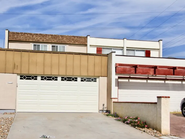Modern-style two-family home with multi-car garage with power lines overhead.