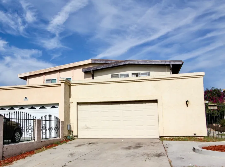 A HOME IN THE HOLIDAY ESTATES WITH THE CAR PARKING, STEEL GATE, PLANTS, FLOWERS