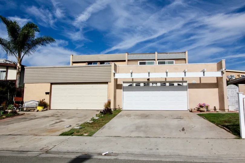 A white garage door with windows next to one without windows in Holiday Estates in Chula vista CA