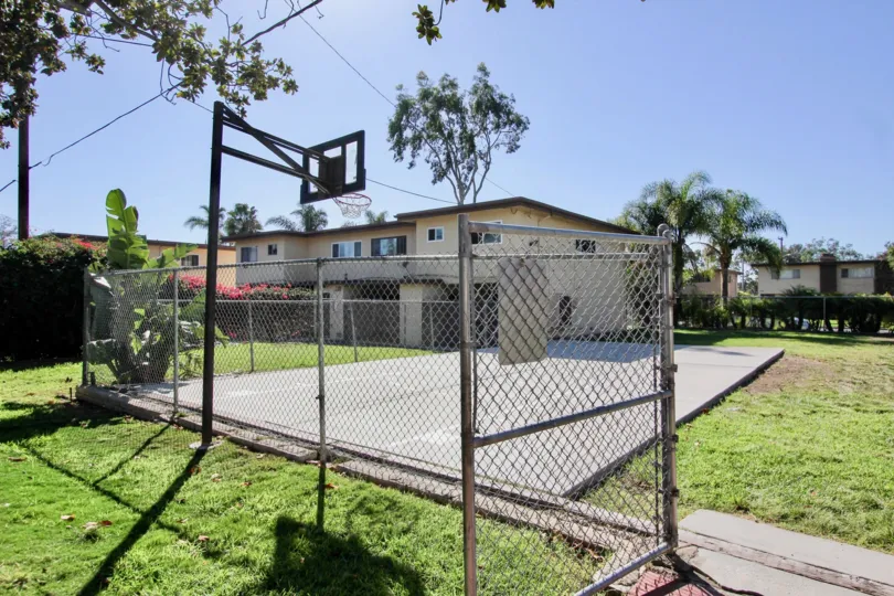 A sunny day at the Holiday Gardens with a basketball court.