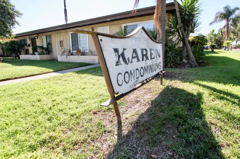 A white and wooden sign announces to visitors they have arrived at the Karen Condominums
