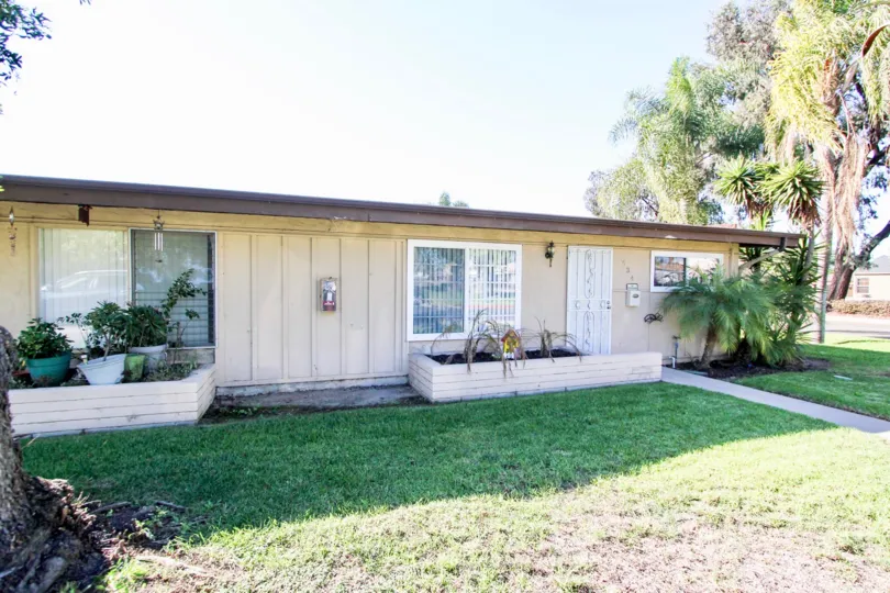 Clean and clear front yard have trees and plants in front of the garage in Karen Condominiums