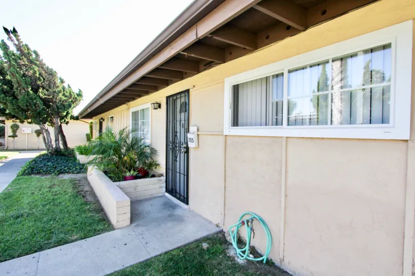 A black security door next to a water hose in front of Karen Condominiums at Chula Vista CA