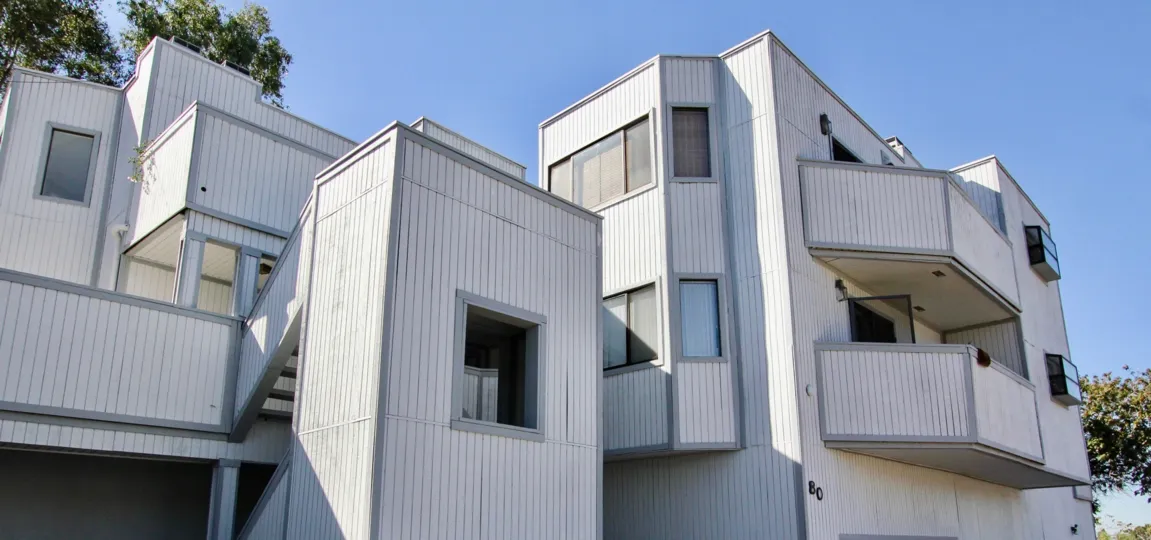 Vertical gray wood paneling covers a building at Kimball Terrace condos