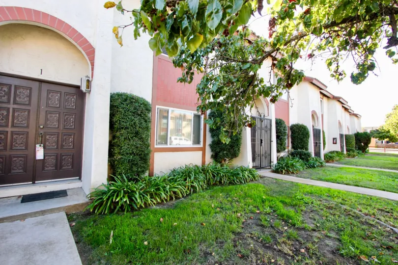 Lawn outside multi-unit dwelling with exterior painted pink, Las Palomas in Chula Vista, CA