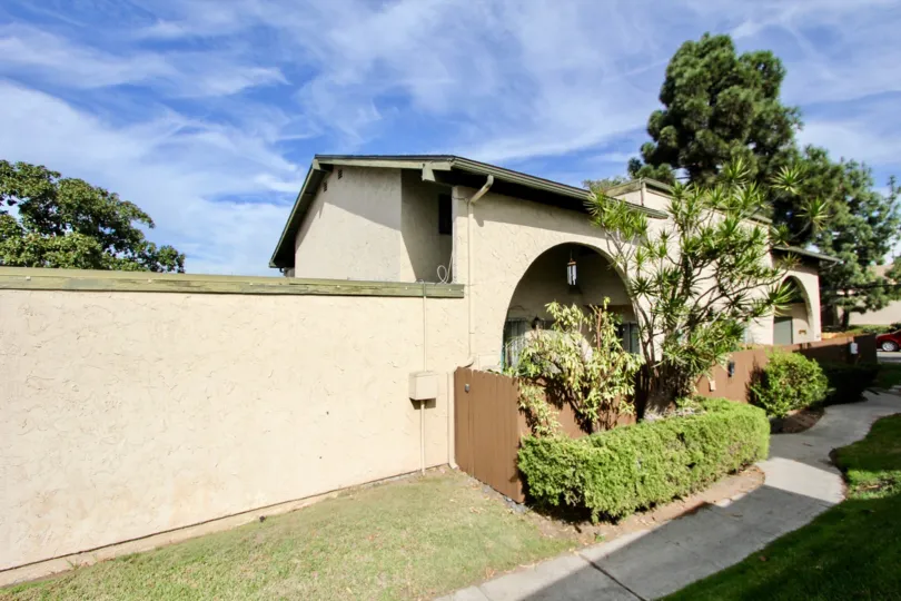A bungalow with green roofing in the Melrose Place Townhomes community on a sunny day.