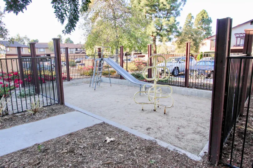 tiny playground with a slide and one other construction for kids to play on, ground is quite dusty