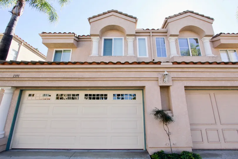 Under the shade of palm trees, a large house looks out onto the community of Serena Condominiums, in Chula Vista, CA.