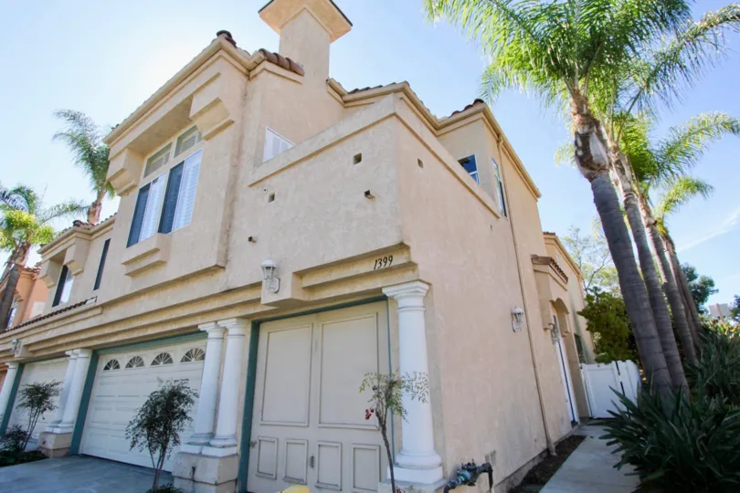 A sunny day in the area of Serena Condominiums, palm trees, garage, columns, balcony, windows,