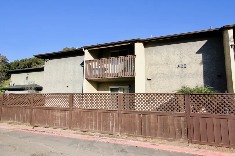 Blue sky with a fence and apartment building in the Shadow Pines Community in Chula Vista, CA.