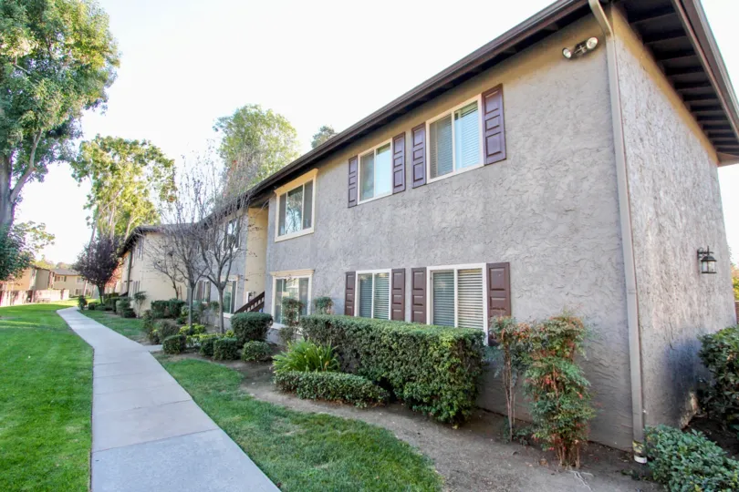 THE APARTMENT IN THE SHADOW PINES WITH THE PATHWAY, LAWN, TREES, PLANTS
