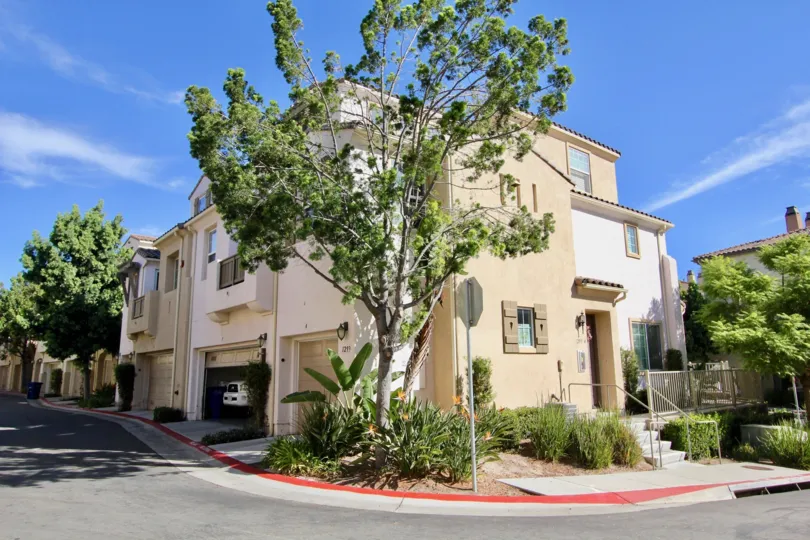A large tree is in front of a house situated on a corner in Silver Sage in California.