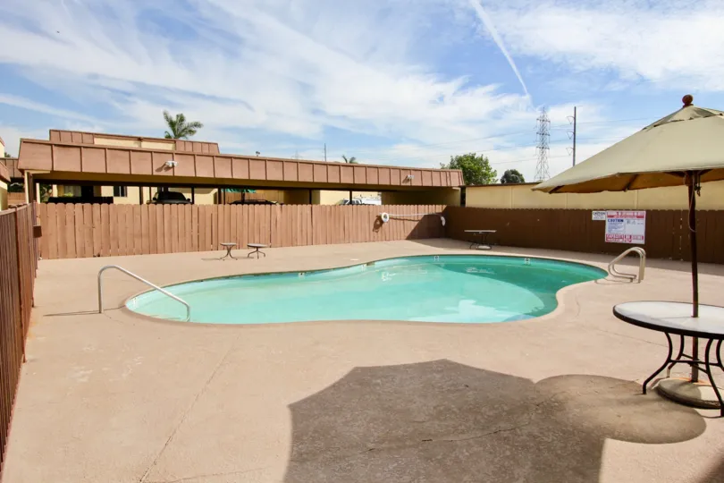 Gated pool area with shaded table on sunny day at Stonebridge II in Chula Vista, California