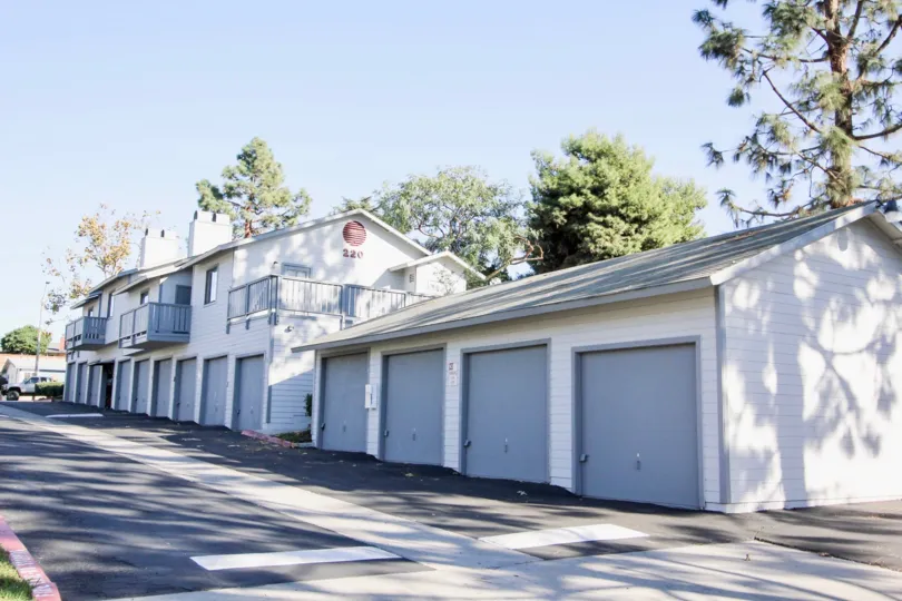 THE BUILDING IN THE SUMMERWIND WITH THE SHUTTERS, TREES, CAR, ROAD