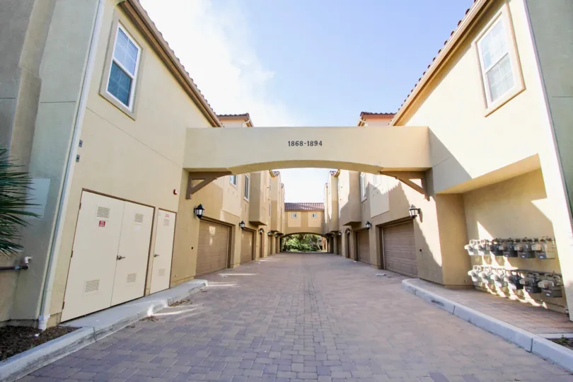 A sunny day in the area of Treviana, outside, driveway, gas meters, doors, archway