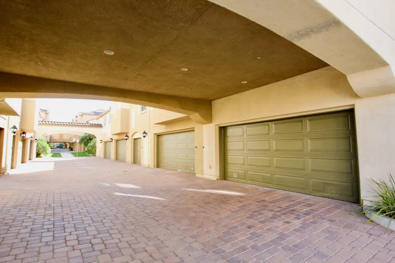 A long red brick driveway lined with garages at Treviana located in Chula Vista CA