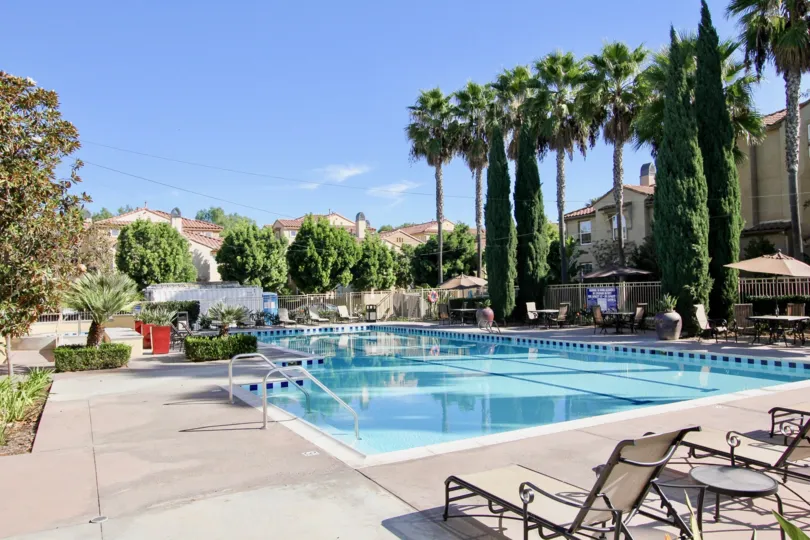A sunny day at the pools with lounge chairs and palm trees in Treviana, Chula Vista, California