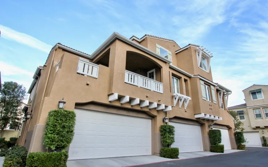 A large house with 3 ground floor garages, clear skies.