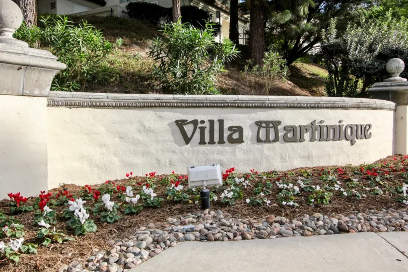 A concrete with stone signage of the Villa Martinique community.