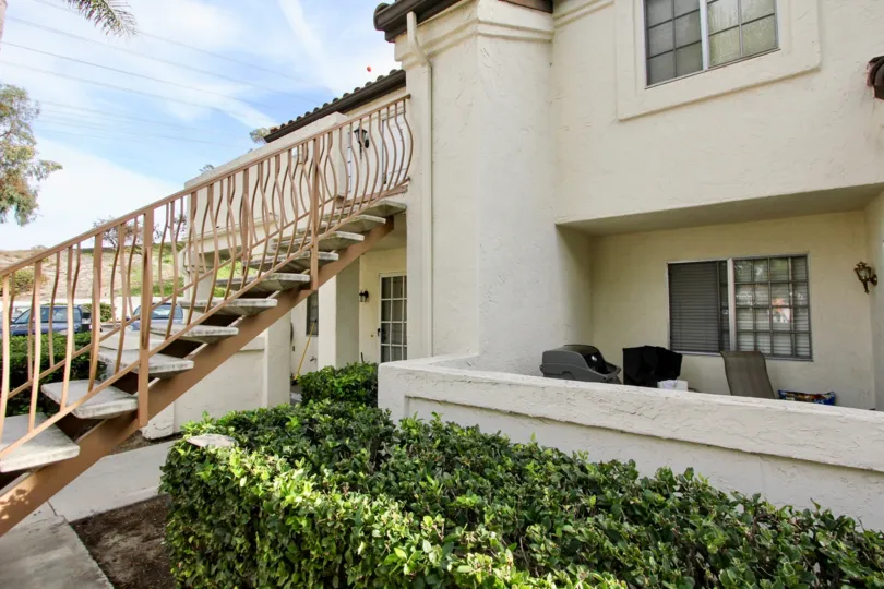 A balcony with a small Garden bush in front of a House with stair case in VIlla Martinique area of Chula Vista