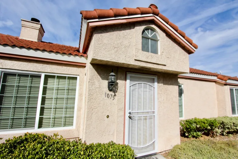A bungalow with ceramic tile roofing and gated front door in the Villa Palmera community.