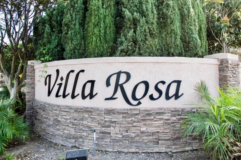 The title sign surrounded by trees and shrubs at Villa Rosa in Chula Vista, California