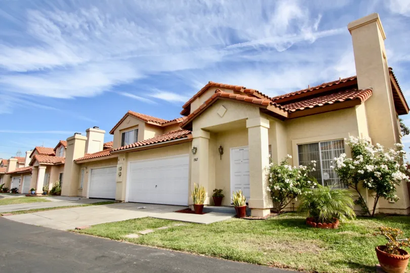 A sunny day in Villa Rosa with a front lawn and a garage.