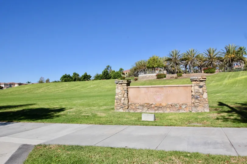 A clear day in Villagio, with a view over the park field and grass.