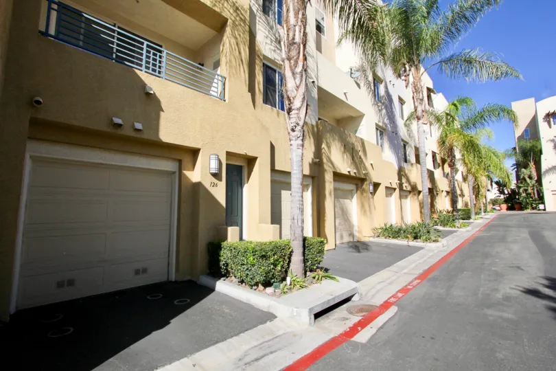 Driveway and garages to apartments at Vellagio with palm trees in Chula Vista, Ca.