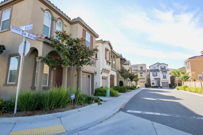 Paved gray road next to trees and buildings at Villas De Avila in Chula Vista CA