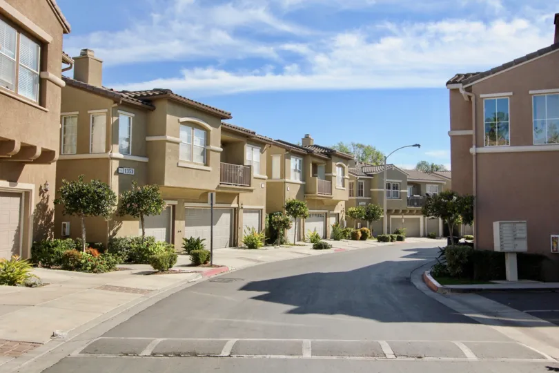 A sunny day in the area of Vista Sonrisa, stree, condos, garage, patio, balcony, trees, bushes
