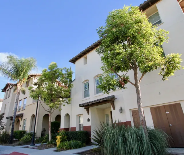 Stucco-style condos with trees annd bushes out front at Winding Walk in Chula Vista, California