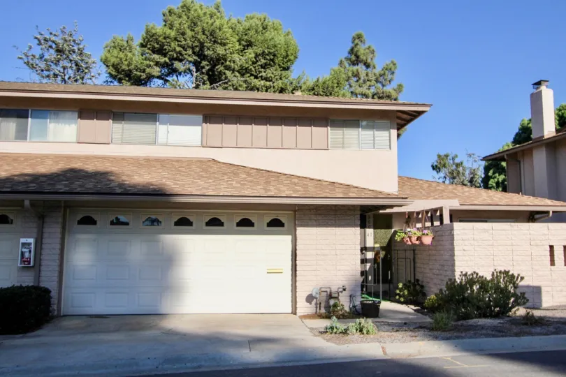 A sunny day in the area of Windsor Heights, outside, garage, entrance, plats, gas meter, trees