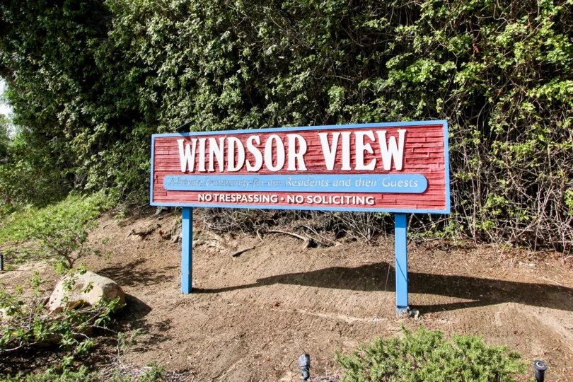 A sunny day in the area of Windsor View. outside, trees, rock, dirt, welcome sign