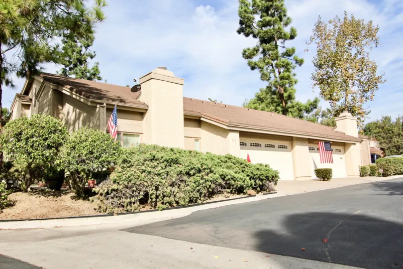 Garage view with American flags and bushes at Windsor View in Chula Vista, California