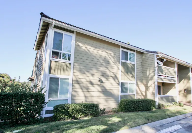 Shrubs and grass outside corner windows at Woodland Hills in Chula Vista, California