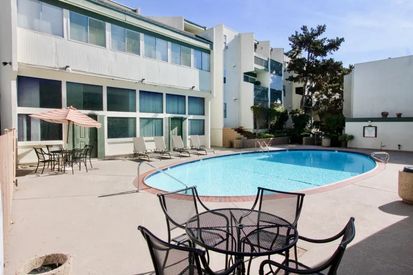 THE APARTMENT IN THE BAY HO WITH THE SWIMMING POO, TABLES, UMBRELLA, PLANTS, TREES