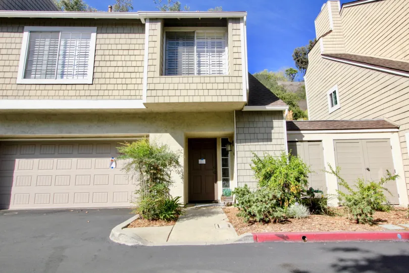 A wooden front door of a big house in a bright sunny day in Canyon Haven community