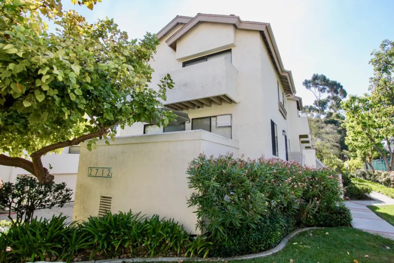 A modern home with stucco exterior and lush greenery in Clairemont Mesa.