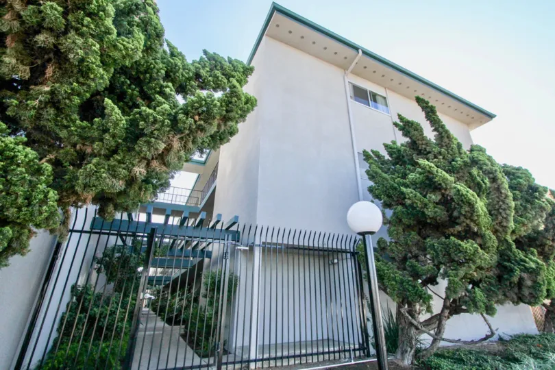Two story apartment building with security fence at Cole Manor in Clairemont Mesa California