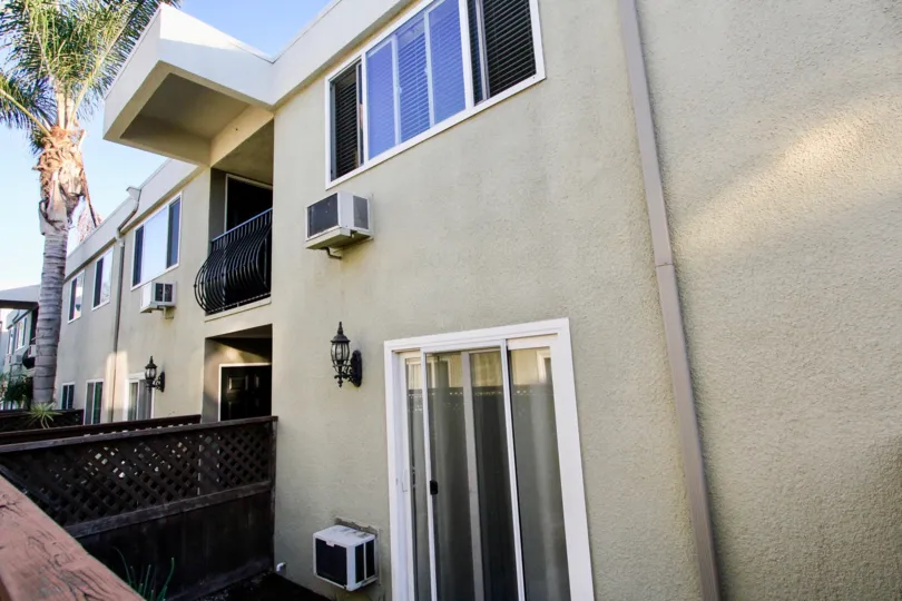 Off white unit with wall air conditioner units and balconies at Heritage Park West of Clairemont Mesa, California