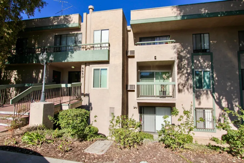 Green plants in front of a story residential building at Amherst Spring in College Area California