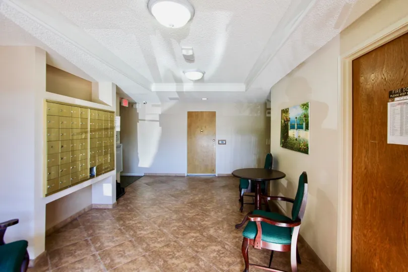 A mailroom with small, golden, key lock boxes in Amherst Spring