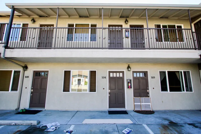 Apartment complex in College area, two level high. Sand colored with dark wood doors.